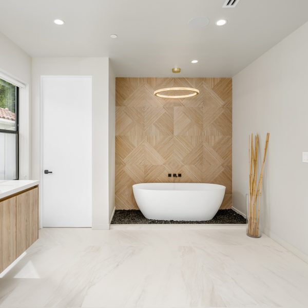 an empty bathtub sits in the middle of a bathroom with wood cabinetry